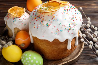 Güzel Paskalya pastaları, yumurtalar ve söğütler ahşap masada, yakın plan.