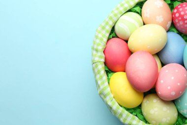 Açık mavi arka planda boyanmış yumurtalar, üst manzara. Metin için boşluk