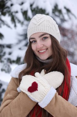 Karlı ormanda köknar ağacının yanında güzel bir kadın.