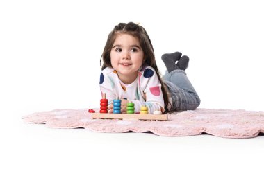 Beyaz arka planda istifleme ve sayma oyunlarıyla oynayan sevimli küçük kız.