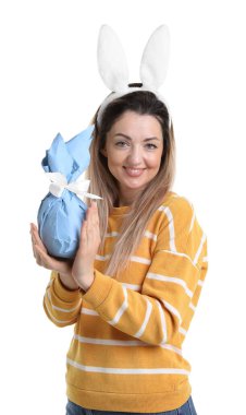 Paskalya kutlaması. Saçbandı takmış, tavşan kulaklı, gülümseyen bir kadın beyaz arka planda hediyesini tutuyor.