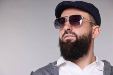 Açık gri arka planda bıyıklı ve sakallı bir adam. Metin için boşluk