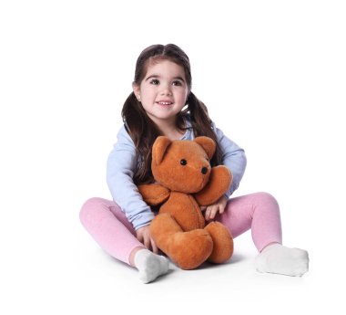 Beyaz arka planda oyuncak ayısı olan sevimli küçük bir kız.