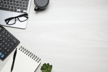Ofis işyeri. Laptop, kahve ve kırtasiye malzemesi beyaz ahşap masada, düz yerde. Metin için boşluk