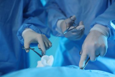 Tıbbi aletleri olan profesyonel cerrahlar ameliyathanede ameliyat yapıyorlar.