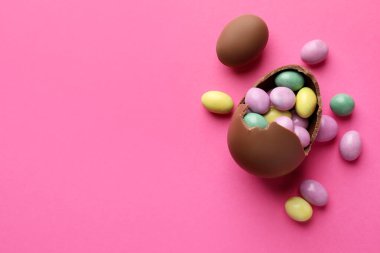 Pembe arka planda şekerli, çikolatalı Paskalya yumurtaları. Metin için boşluk