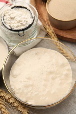 Çiğ hamur, malzemeler ve çiviler gri masada, yakın plan.