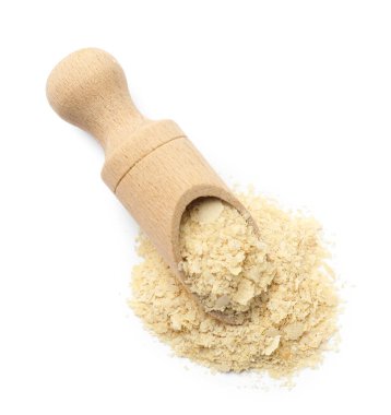 Beyaz arka planda kepçe halinde kuru maya taneleri, üst görünüm