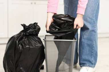 Mutfakta çöp poşetini değiştiren kadın, yakın çekim.