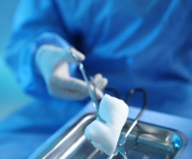 Hastanedeki masada farklı cerrahi aletleri olan doktor, yakın plan.