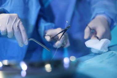 Tıbbi aletleri olan profesyonel cerrahlar ameliyathanede ameliyat yapıyorlar.