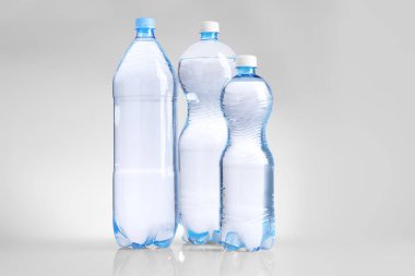 Farklı boyutlarda su şişeleri beyaz üzerine izole edilmiş.