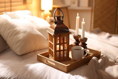 Güzel bir Noel feneri, yanan mumlar ve sıcak bir bardak içecekle birlikte.