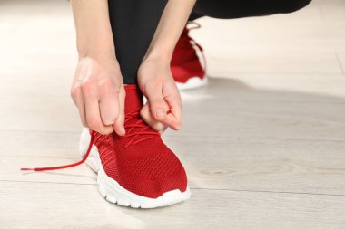 Kırmızı spor ayakkabı bağcığı bağlayan kadın, yakın plan.