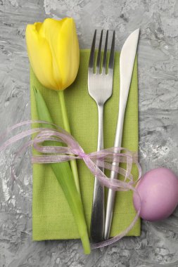 Paskalya sofrası. Lale ve yumurta desenli gri arka planda güzel gümüş takımlar.