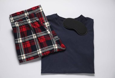 Beyaz arka planda şık pijama ve uyku maskesi, üst görünüm