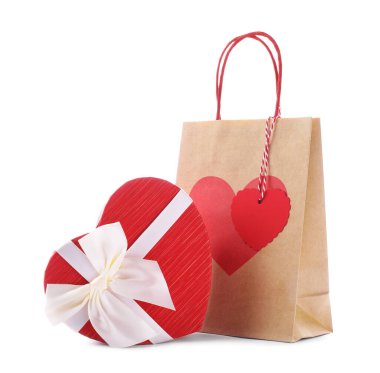 İçinde kalp şeklinde hediye paketi olan kağıt torba beyaza izole edilmiş. Sevgililer Günü