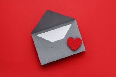 Sevgililer Günün kutlu olsun. Tebrik kartı ve kırmızı arka planda dekoratif kalp ile zarf, üst görünüm