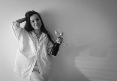 Doğum günü kutlaması. Evdeki yatakta cam ve köpüklü şarapla güzel bir kadın. Siyah ve beyaz etkisi