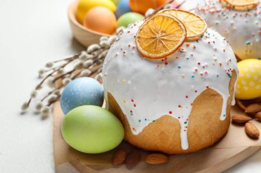 Lezzetli Paskalya pastaları, boyanmış yumurtalar ve söğüt dalları beyaz masada, yakın plan.