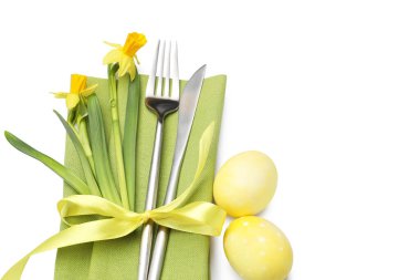 Paskalya sofrası. Nergisli güzel gümüş takımlar ve beyaza izole edilmiş yumurtalar.
