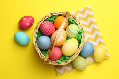 Sarı arka planda boyanmış yumurtaları olan Paskalya sepeti.