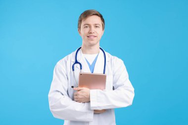 Açık mavi arkaplanda tableti olan bir tıp asistanı portresi