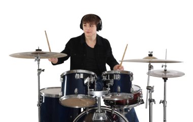 Kulaklıklı, bagetleriyle davul çalmayı öğrenen genç bir çocuk.