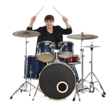 Elinde bagetlerle gülümseyen genç çocuk beyaz arka planda davul çalmayı öğreniyor.