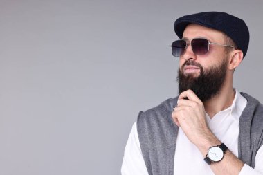 Açık gri arka planda bıyıklı ve sakallı bir adam. Metin için boşluk