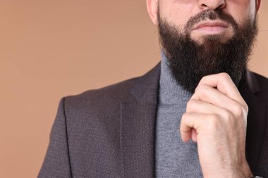 Bıyıklı ve sakallı adam bej arka planda, yakın plan. Metin için boşluk