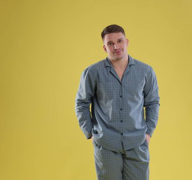 Sarı arka planda şık pijamalı bir adam.