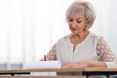 Üst düzey kadın son arzusunu ve vasiyetnamesini masa içinde imzalıyor. Mesaj için yer var.