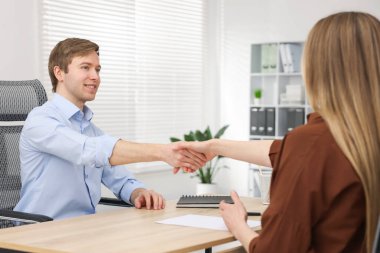 Gülümseyen asker ve aday ofiste el sıkışıyor.