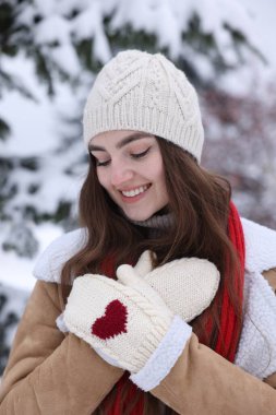 Karlı ormanda köknar ağacının yanında güzel bir kadın.