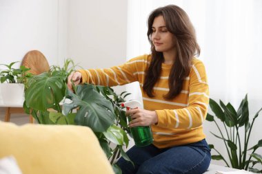 Bir kadın evin içine su püskürtüyor.