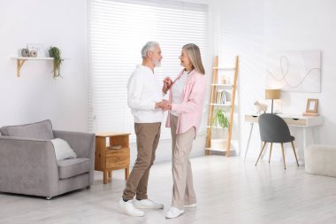 Güzel yaşlı çift evde dans ediyor.