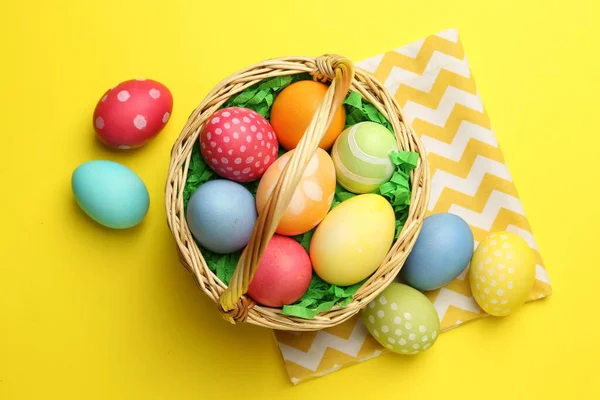 Sarı arka planda boyanmış yumurtaları olan Paskalya sepeti.