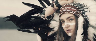 Hayvan ruhlu bir şaman kadın. Kızılderili başlıklı ve kargalı kız.