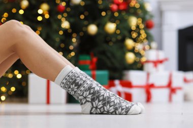 Evde Noel ağacına karşı rahat çorap giyen bir kadın, yakın plan. Metin için boşluk