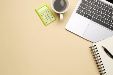 Ofis işyeri. Kırtasiye malzemesi, dizüstü bilgisayar ve bej arka planda kahve, düz yatak. Metin için boşluk