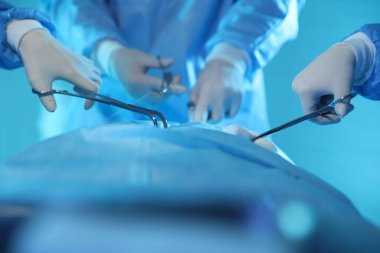 Tıbbi aletleri olan profesyonel cerrahlar ameliyathanede ameliyat yapıyorlar.