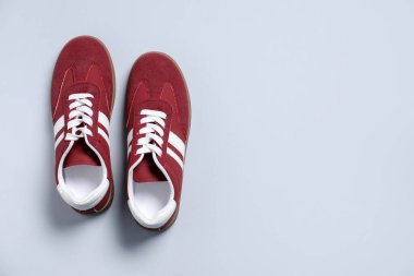 Gri arka planda bir çift şık spor ayakkabı, üst manzara. Metin için boşluk