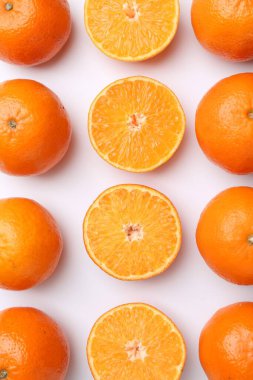 Beyaz arka planda taze taze mandalinalar, düz uzanmış.