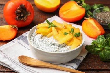 Kavanozda nefis chia pudingi, hurma, nane ve kaşık ahşap masada, yakın plan.