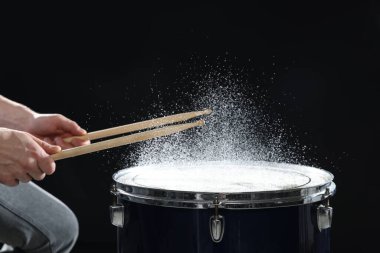 Siyah arkaplanda davul çalan bagetli adam, yakın plan