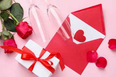 Sevgililer Günü. Zarfta aşk mektubu, kırmızı kalp, hediye, pembe arka planda gözlük ve güller, düz uzanma