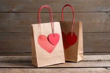 Tahta masada üzerinde kalp izleri olan kağıt torbalar.