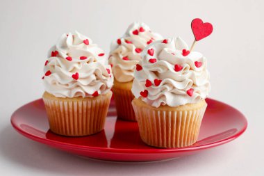 Sevgililer Günün kutlu olsun. Açık gri arkaplanda kalp şeklinde serpiştirilmiş lezzetli kekler, yakın plan.