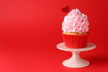 Sevgililer Günün kutlu olsun. Kırmızı arka planda kalp kaplaması olan leziz bir kek, yakın plan. Metin için boşluk